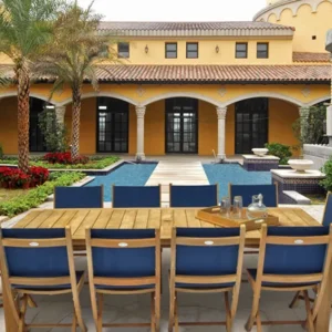 family extension table with folding side chairs by royal teak in a patio backyard with a large yellow house